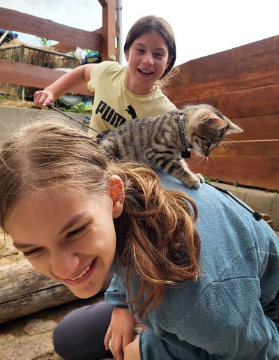 Zwei lächelnde Mädchen spielen auf dem Boden