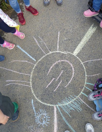 große, bunte Sonne mit Kreide gezeichnet