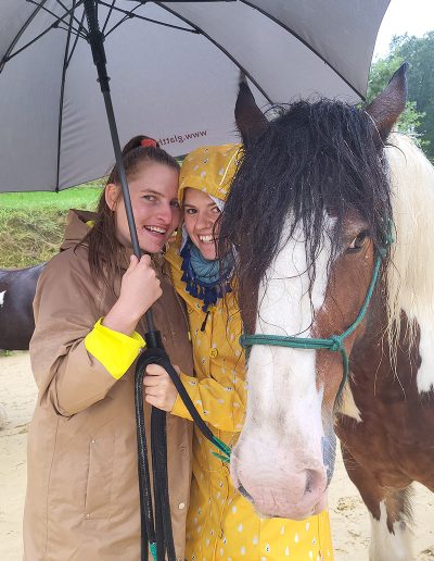 Zwei lächelnde Frauen in Regenmänteln